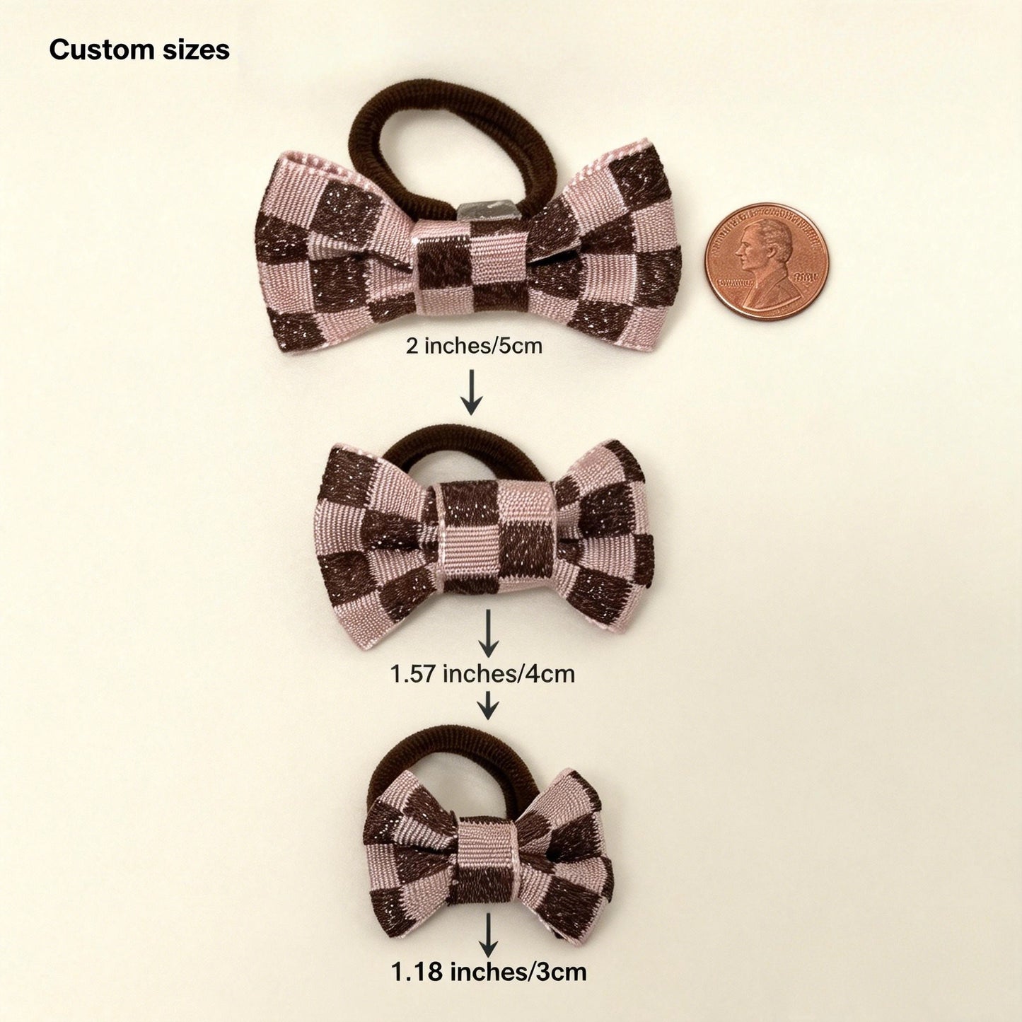 SilkyCo Handcrafted Checkerboard Pet Hair Bow Custom Sizing Guide. See how to customize for your pet: The bow size (2in/5cm, 1.57in/4cm, 1.18in/3cm) can be tailored to their head circumference—we recommend a length no more than half for a perfect, comfy fit. Pair it with your choice of a 2.5cm (1in) elastic tie or a clip in 2.3cm/0.9in, 2.8cm/1.1in, or 3.2cm/1.26in. A US penny sits nearby for easy scale reference.