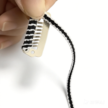 Close-up detail of SilkyCo Cozy Embrace Collection dog barrette, showcasing the handmade craftsmanship. A maker’s hand demonstrates the thick, soft brushed fabric with black ribbon and white edge, tightly hand-wrapped around the sturdy 301 stainless steel clip base.