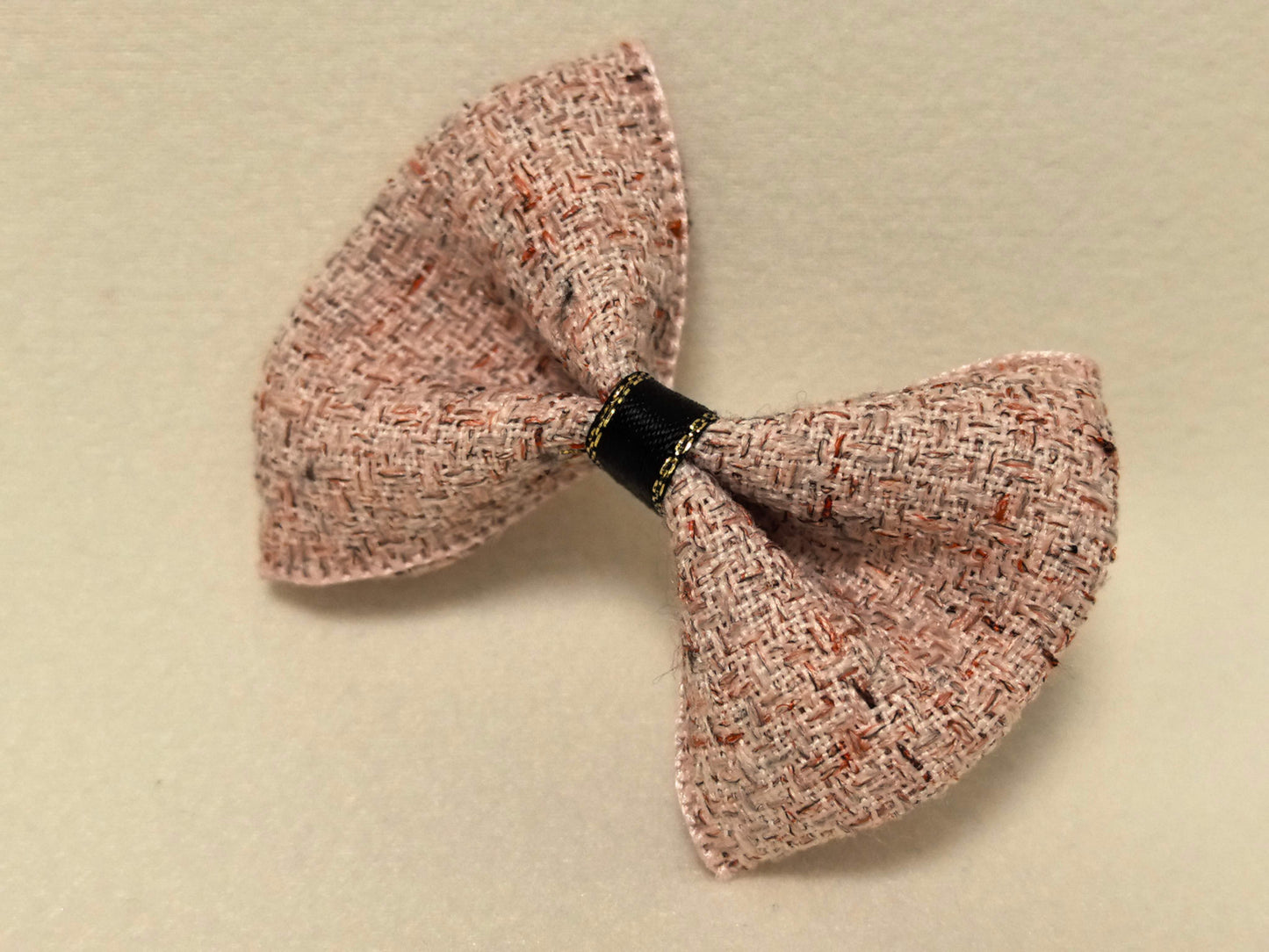 Macro detail highlighting the woven texture and gold stitching on the Dusty Rose Tweed Bow.