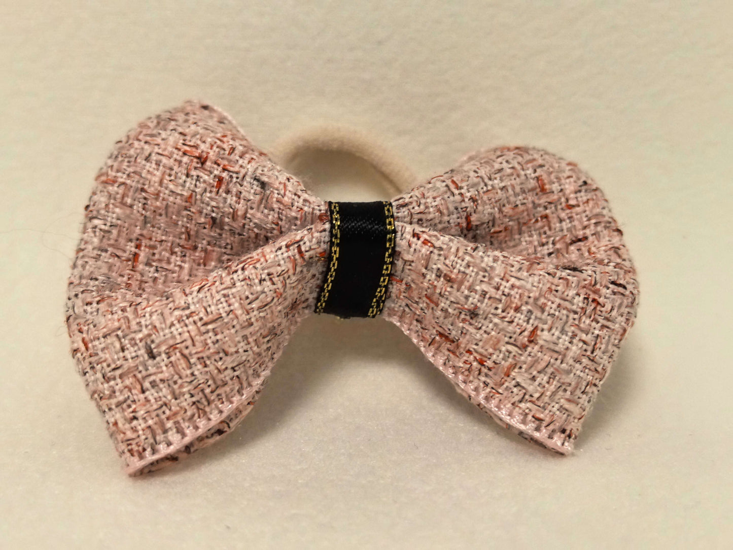 Top-down view of the SilkyCo Tweed Bow in Dusty Rose, showcasing the gold-tone clasp.