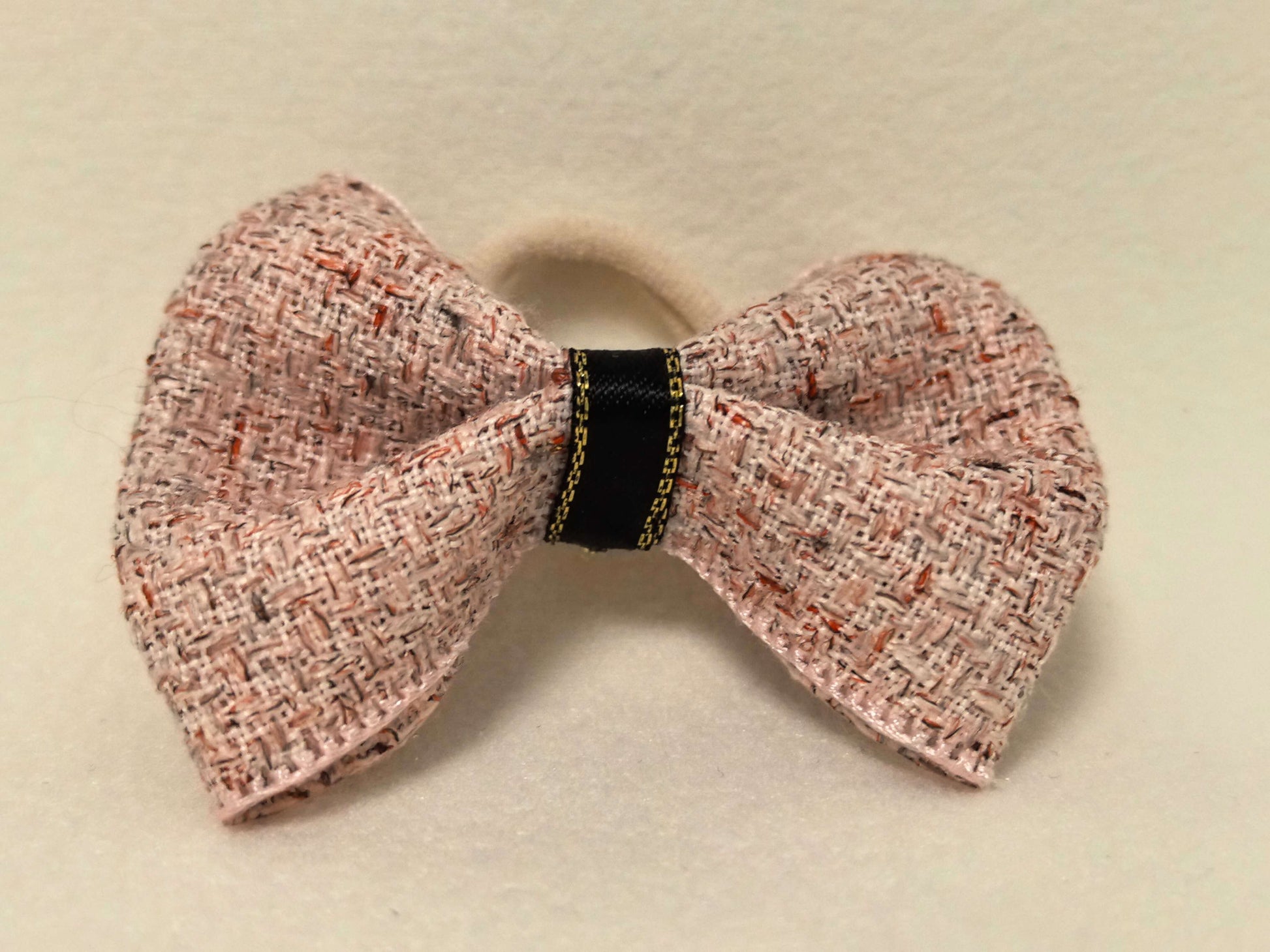 Top-down view of the SilkyCo Tweed Bow in Dusty Rose, showcasing the gold-tone clasp.