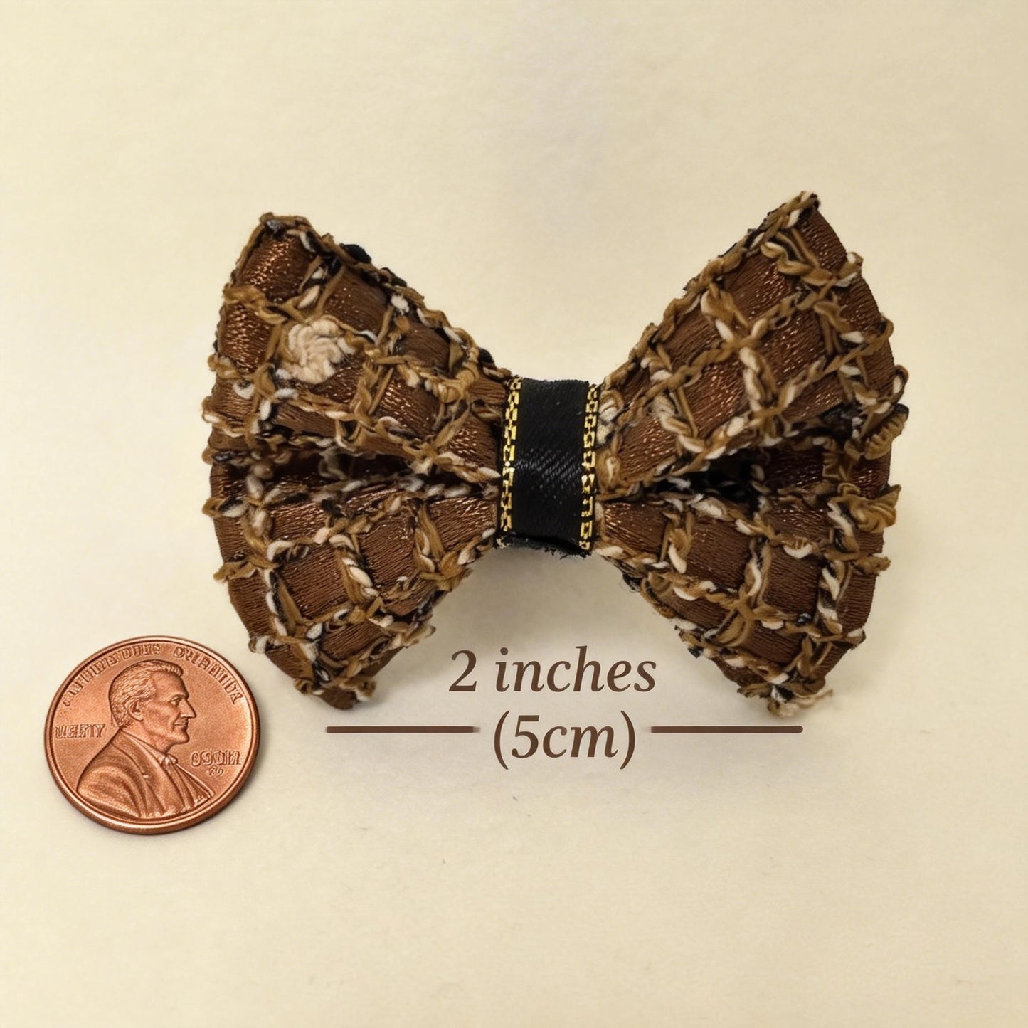 SilkyCo Gala Collection Detachable Woven Mesh Pet Hair Bow size chart. The image clearly shows the dog bow's actual size of 2 inches (5cm) alongside a US penny (1-inch diameter) for scale, on a pure white background.