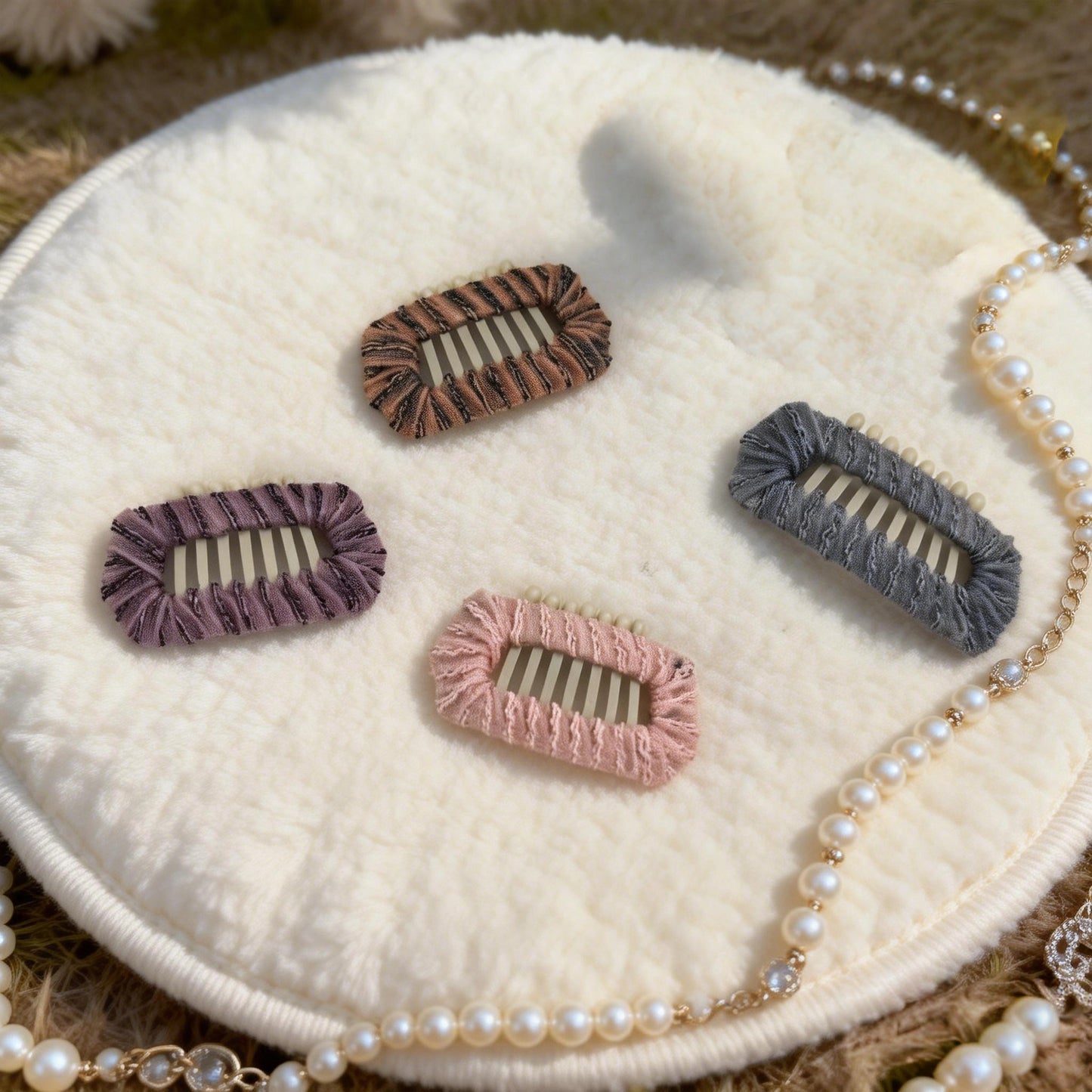 SilkyCo Vintage Lace Dog Barrettes 4-Piece Set in purple, brown, pink, and misty blue, displayed on a white fluffy surface with a pearl necklace. Each barrette features exquisite 3mm embroidered lace hand-wrapped on a stainless steel base for a retro, elegant pet styling accessory.
